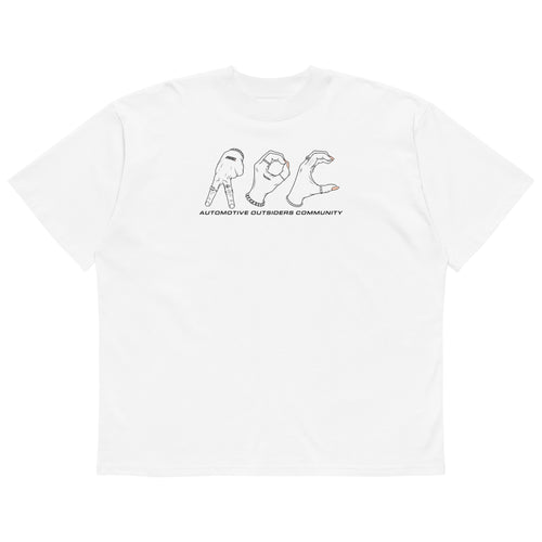 Camiseta oversized blanca de AOC con ilustración de manos formando las letras AOC y el texto Automotive Outsiders Community.