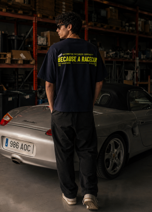 Camiseta Oversized “Because A Racecar” azul marino vista trasera con gráfica amarilla