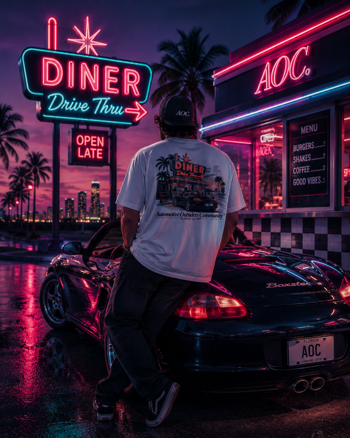 Camiseta Porsche Boxster 986 DriveThru blanca con estampado trasero de diner y coche, usada por modelo en escena nocturna con neones