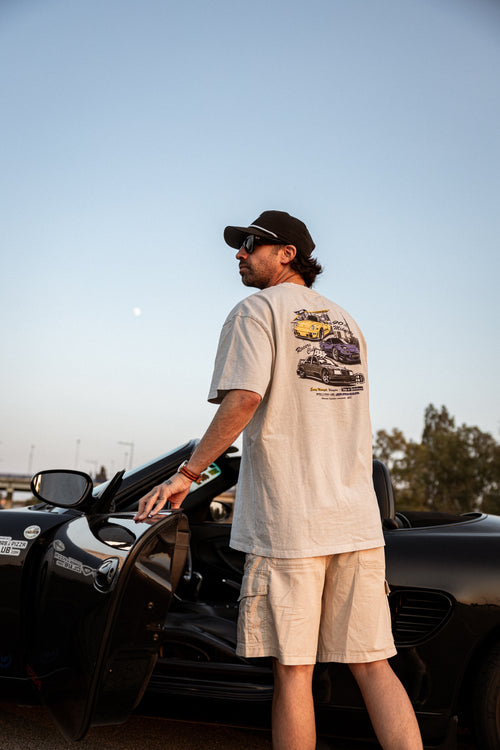 Camiseta Racers Club Midnight Series con estampado trasero de coches, usada por modelo junto a coche descapotable negro