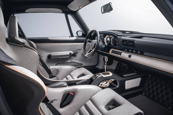 Interior de coche deportivo con asientos, volante y salpicadero