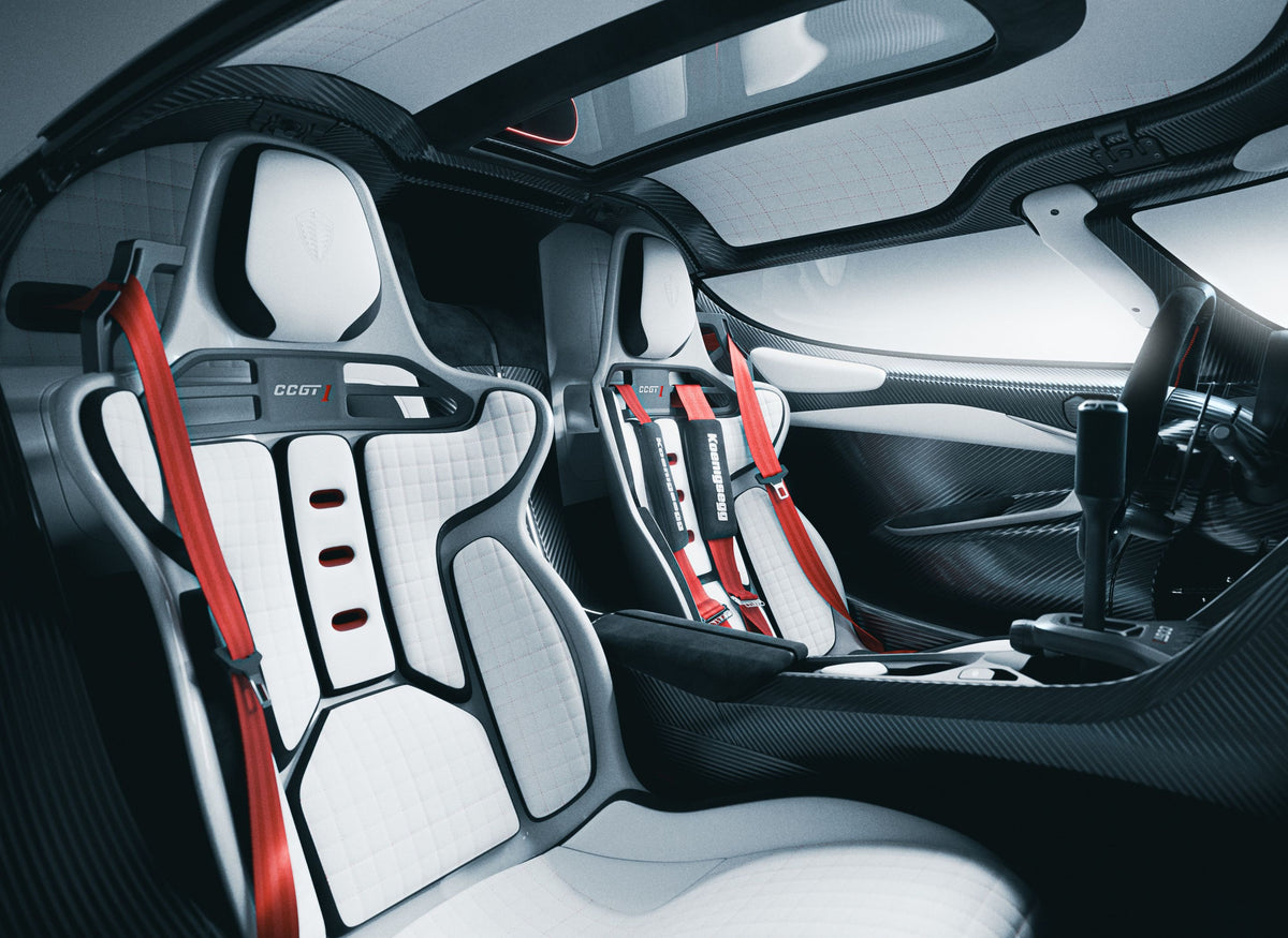 Interior del Koenigsegg CCGT1 con asientos blancos arneses rojos y carbono visto