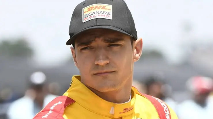 Piloto de automovilismo con gorra negra y mono amarillo de competición