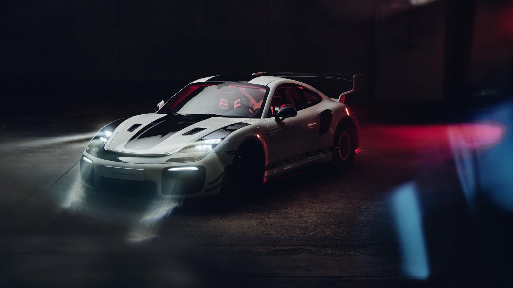 Porsche Flachbau RS iluminado en ambiente oscuro con los faros delanteros encendidos